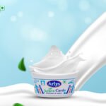 Container of Arlys Active Curd with a white milk splash against a blue background, conveying freshness and energy.