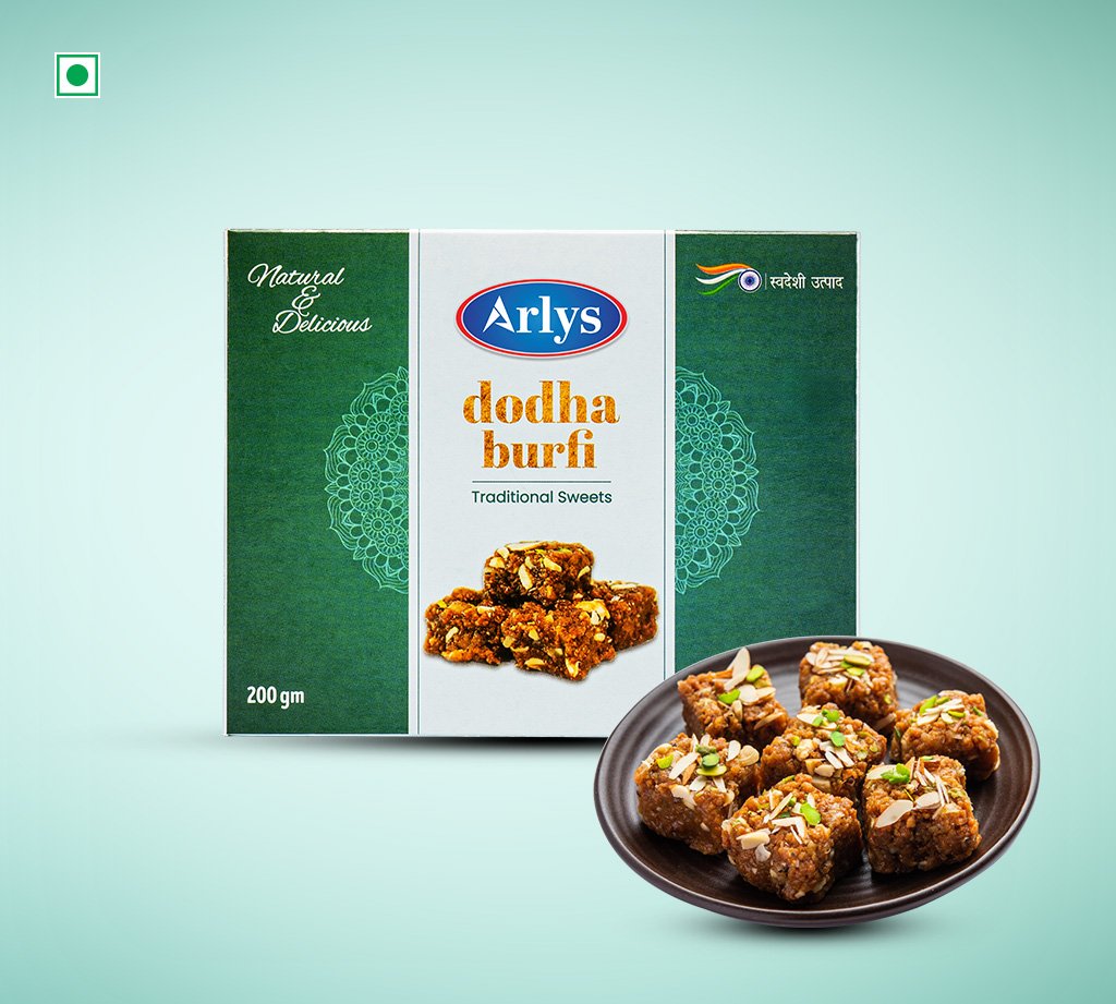 Arlys dodha burfi traditional sweets box with a plate of chopped burfi pieces topped with nuts on a mint backdrop