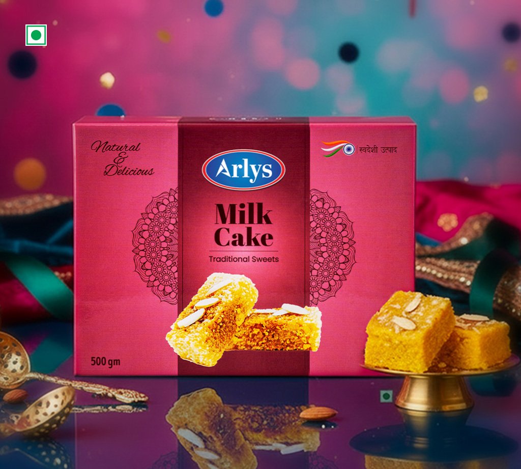 Pink Arlys Milk Cake box with traditional sweets, showing pieces of cake in front on a reflective surface.