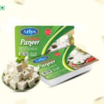 Green packaging of Arlys Premium Paneer with a bowl of cubed paneer in the foreground.
