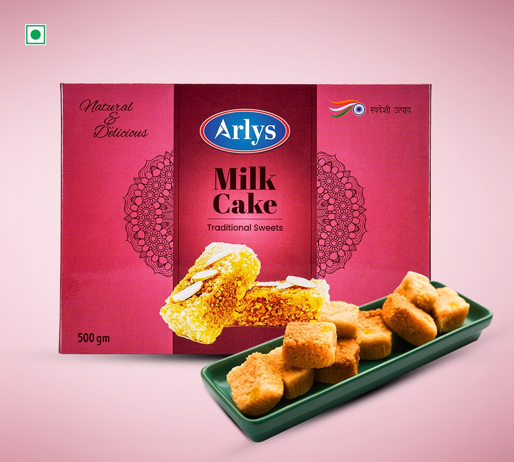Pink Arlys Milk Cake box for traditional Sweets; plate of bite-sized fried cubes on a green tray in front.