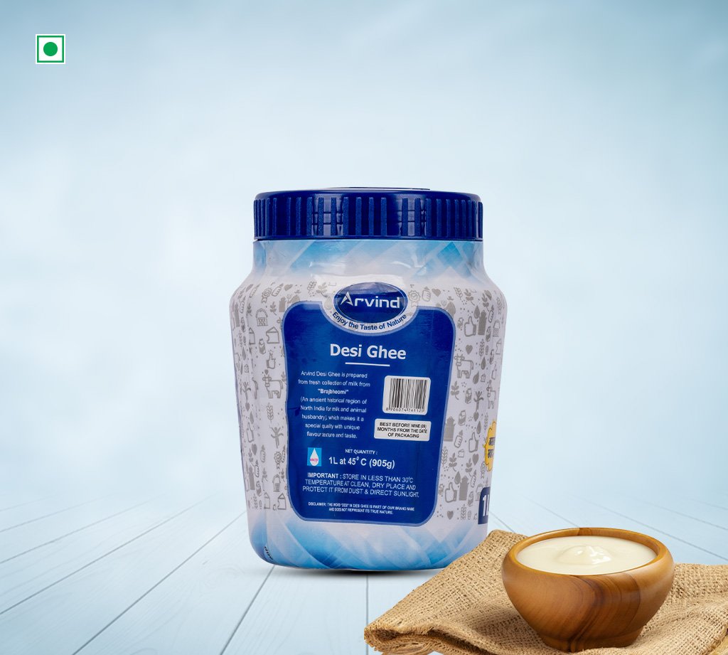 Jar of Arvind Desi Ghee with a blue lid on a pale blue backdrop, a small wooden bowl of ghee on burlap nearby.