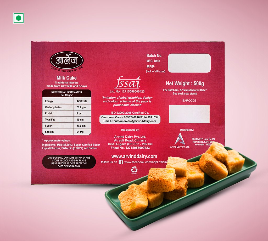 Red box labeled Milk Cake with nutrition panel and a green tray of cubed fried sweets in front on a pink background