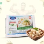 Front of Arlys Masala Tofu package with a bowl of cubed tofu beside it; faint muscular figure in background.