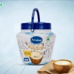 Blue-lid Arvind Desi Ghee tub (1800 ml) with spoon and a bowl of ghee beside it on a light background.