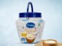 Blue-lid Arvind Desi Ghee tub (1800 ml) with spoon and a bowl of ghee beside it on a light background.
