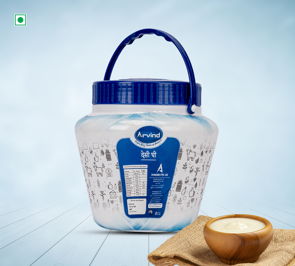 Arvind dairy product in a large white container with a dark blue lid, shown on a light wooden floor with a small bowl of cream on burlap nearby.
