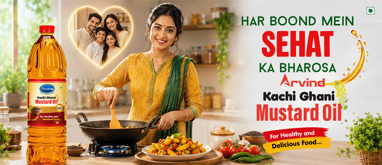 Indian woman cooking in a bright kitchen with Arvind Kachi Ghani Mustard Oil on the counter and a heart-shaped family photo in the background.