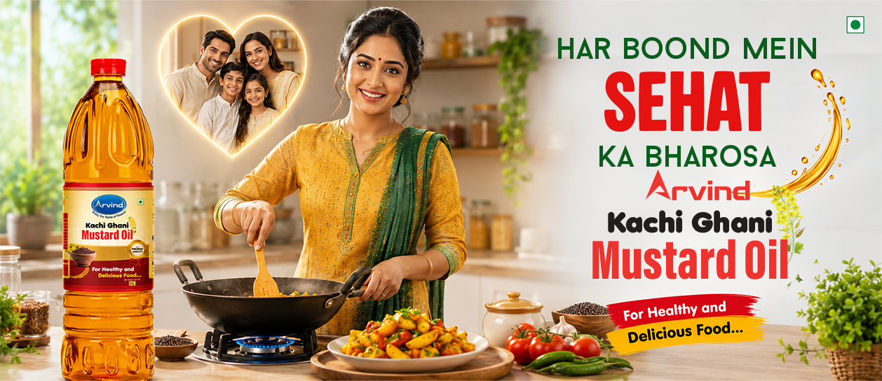 Indian woman cooking in a bright kitchen beside a large bottle of Arvind Kachi Ghani Mustard Oil; a heart-shaped photo of a family and bold ad text on the right promoting healthful cooking.
